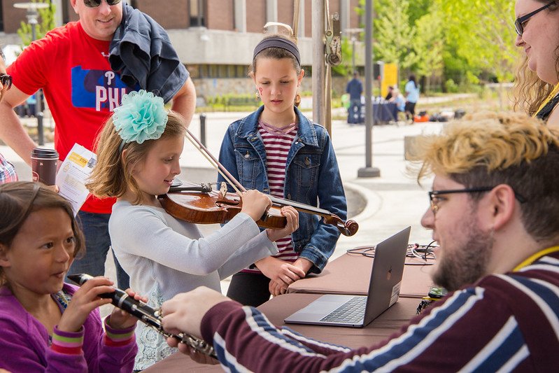 student showing little kids about some instruments
