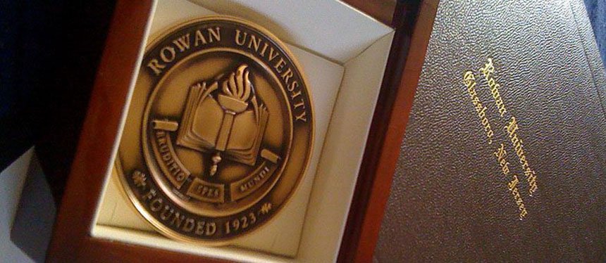 medallion award in a box with a diploma cover in the background