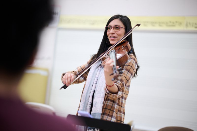 Explore undergraduate programs, a professor playing a violin while instructing a class