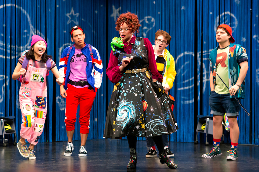 4. Miss Frizzle, mid-speech, surrounded by her “students” enthusiastically listening.
