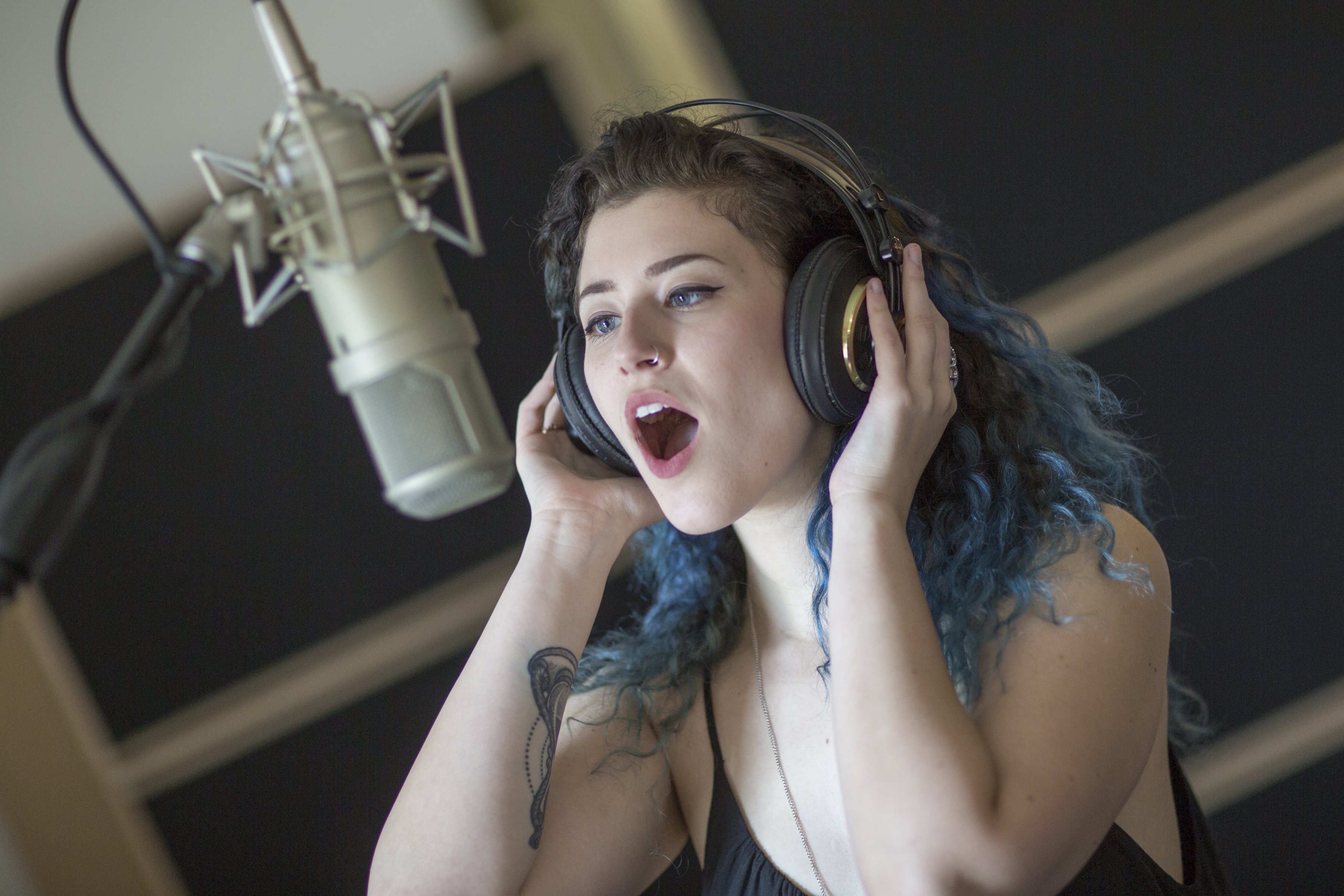 Rowan Music Group recording artist, sof, singing in the studio with headphones and mic