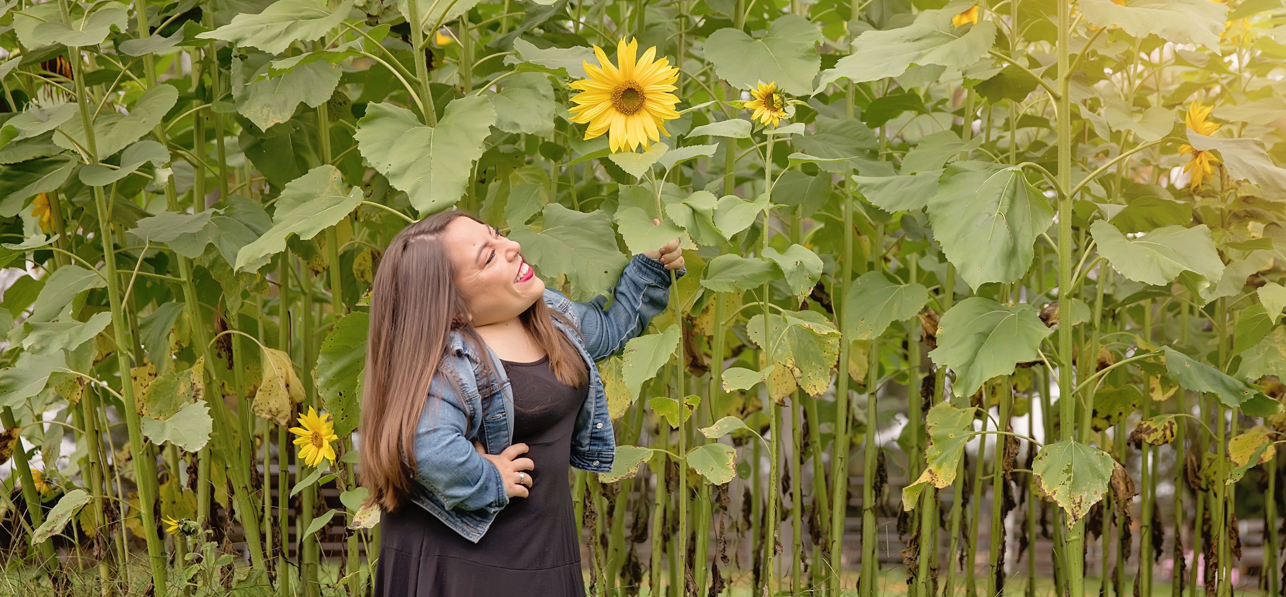 Mackenzie smelling a sunflower.